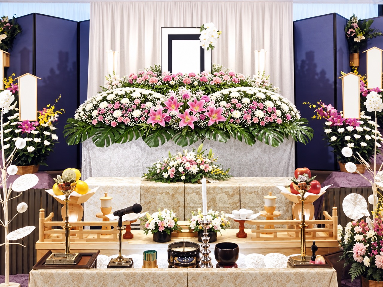 白とピンクの花で飾られた一般葬の生花祭壇例